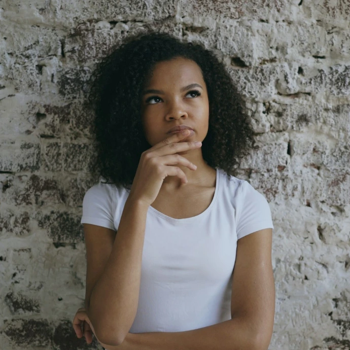 Young woman with hand on chin thinking